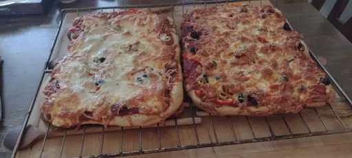 two pizzas on cooling on a rack