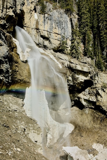 Panther Falls with the remaining snow chunks scartered about the landscape, with a nice rainbow being formed in the mist from the falls.