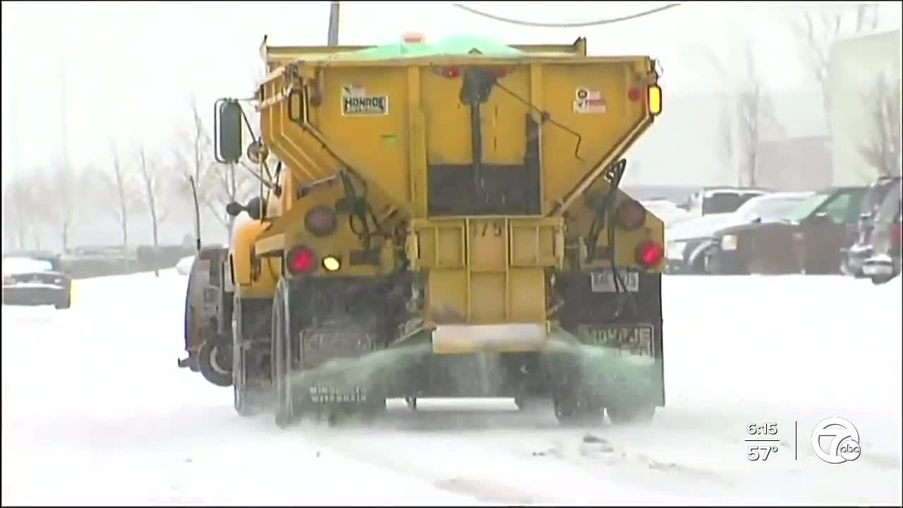 a snowplow spraying a salt mixture to help prevent icing on the roads. 